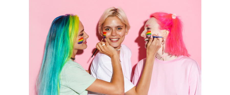 3 women applying rainbow pride makeup